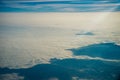 Plane window view of clouds and islands surrounded by sea and airplane wing. Traveling concept Royalty Free Stock Photo