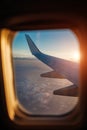 Plane window view of clouds and islands surrounded by sea and airplane wing. Traveling concept Royalty Free Stock Photo