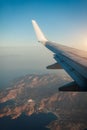 Plane window view of clouds and islands surrounded by sea and airplane wing. Traveling concept Royalty Free Stock Photo