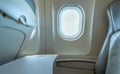 Plane window with white sunlight. Empty plastic airplane tray table at seat back. Economy class airplane window. Inside of