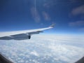 Plane wing blue sky white clouds flight window Royalty Free Stock Photo