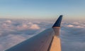 Plane wing in flight at sunset Royalty Free Stock Photo