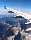 Plane wing over Alps, Summer with mountains below Royalty Free Stock Photo