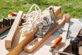 Plane, wooden blanks and tools lie on the table of the carpentry workshop on a sunny day. Royalty Free Stock Photo