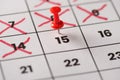 Planed meeting is here concept. Cropped close up view photo of red pushpin attached to calendar with date 15th with crossed