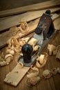 Planer and shavings after planing wooden boards on the workbench.