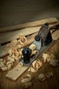 Planer and shavings after planing wooden boards on the workbench, vertical photo