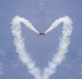 Planes forming a heart shape with tracks on the blue sky Royalty Free Stock Photo