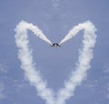 Planes forming a heart shape with tracks on the blue sky Royalty Free Stock Photo