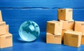 Planet Earth globe and cardboard boxes mass consumption products. Delivering goods around the world. International trade and Royalty Free Stock Photo