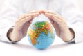 Planet Earth globe protected by hands