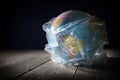 Planet Earth in polyethylene plastic disposable trash bag