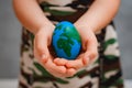 planet Earth in the shape of an egg in children& x27;s hands close-up. The concept of global problems of humanity, peace Royalty Free Stock Photo