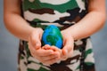 planet Earth in the shape of an egg in children& x27;s hands close-up. The concept of global problems of humanity, peace Royalty Free Stock Photo