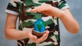 planet Earth in the shape of an egg in children& x27;s hands close-up. The concept of global problems of humanity, peace Royalty Free Stock Photo