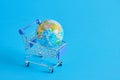 a planet earth in a supermarket shopping cart on blue background. copy space Royalty Free Stock Photo