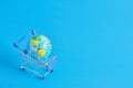 a planet earth in a supermarket shopping cart on blue background. copy space Royalty Free Stock Photo