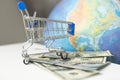 a planet earth in a supermarket shopping cart on blue background. copy space shopping trolley and toy ball in form of Royalty Free Stock Photo