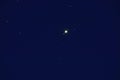 Planet jupiter seen from earth on night sky with four satellites