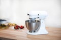 Planetary mixer on a table with fruit on a white background