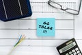 Switching to solar power. Blueprints and solar cells with calculator, eyeglasses and cable Royalty Free Stock Photo