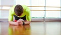 Plank it Confident muscled young man wearing sport wear and doing plank position while exercising on the floor in loft Royalty Free Stock Photo