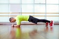 Plank it Confident muscled young man wearing sport wear and doing plank position while exercising on the floor in loft Royalty Free Stock Photo