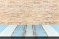 Plank wood or table top with blurred synthetic wall brick background. Royalty Free Stock Photo