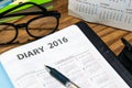 Daily planner book in black leather case with glasses and pen Royalty Free Stock Photo