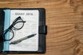 Daily planner book in black leather case with glasses and pen Royalty Free Stock Photo