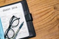 Daily planner book in black leather case with glasses and pen Royalty Free Stock Photo