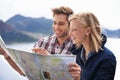 Planning the best way to get there. A shot of a young couple studying a map on their road trip. Royalty Free Stock Photo
