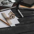 Planning of the construction of a house. Office desk with business objects - open notebook, tablet computer, glasses, ruler, pen a Royalty Free Stock Photo