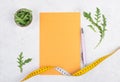 Planning a diet, arugula salad and tailor tape measure around the empty paper, healthy food and lifestyle, loosing weight Royalty Free Stock Photo