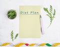 Planning a diet, arugula salad and tailor tape measure around the empty paper, healthy food and lifestyle, loosing weight