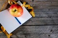 Planning of a diet. A notebook c an inscription - the Diet, a measuring tape, an apple and pen