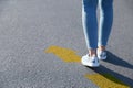 Planning future. Woman walking towards drawn mark on road, closeup. Yellow arrow showing direction of way Royalty Free Stock Photo