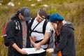 Planning, hiking and friends with a map, travel and direction with health, journey and lost. People, men and women with