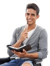 Planning keeps him punctual. Portrait of a handsome young man sitting with diary in hand and smiling against a white Royalty Free Stock Photo