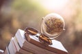 Planning the next journey: Miniature globe and sunglasses on a stack of books