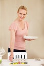 Planning the perfect dinner party. A beautiful woman setting the table at home. Royalty Free Stock Photo