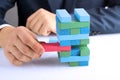 Planning, risk and strategy in business, businessman getting out a wooden block from a tower