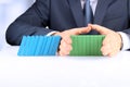 Planning, risk and strategy in business, businessman holding wooden blocks. Businessman Stopping The Effect Of Domino