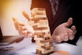 Planning, risk and strategy in business concept, businessman gambling placing wooden block on a tower