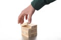 Planning strategy concept: man`s hand move a toy wooden block from a tower of blocks with copy space for your text Royalty Free Stock Photo