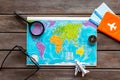 Planning a travel concept. Map of the world and tourist accessories on dark wooden background top view Royalty Free Stock Photo