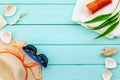 Summer travaling to the sea with straw hat, sun glasses, sunblock lotion on mint green background top view mock up