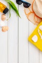 Summer travaling to the sea with straw hat, sun glasses, sunblock lotion on white wooden background top view mock up