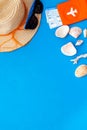 Summer travaling to the sea with straw hat, sun glasses, tickets and passport on blue background top view mock up