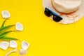 Summer travaling to the sea with straw hat, sun glasses, shells on yellow background top view mock up